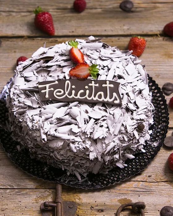 Pastís de xocolata amb una placa de Felicitats