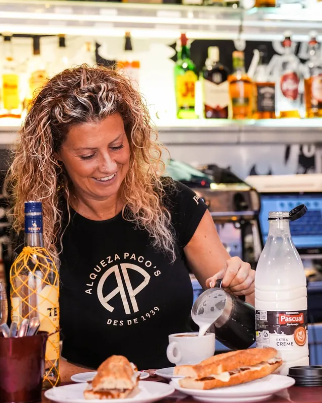 Una cambrera de Paco’s serveix un cafè amb llet i un entrepà